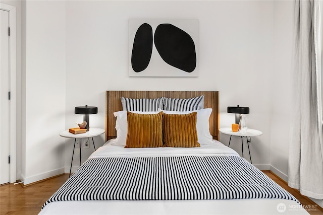 bedroom with baseboards and wood finished floors