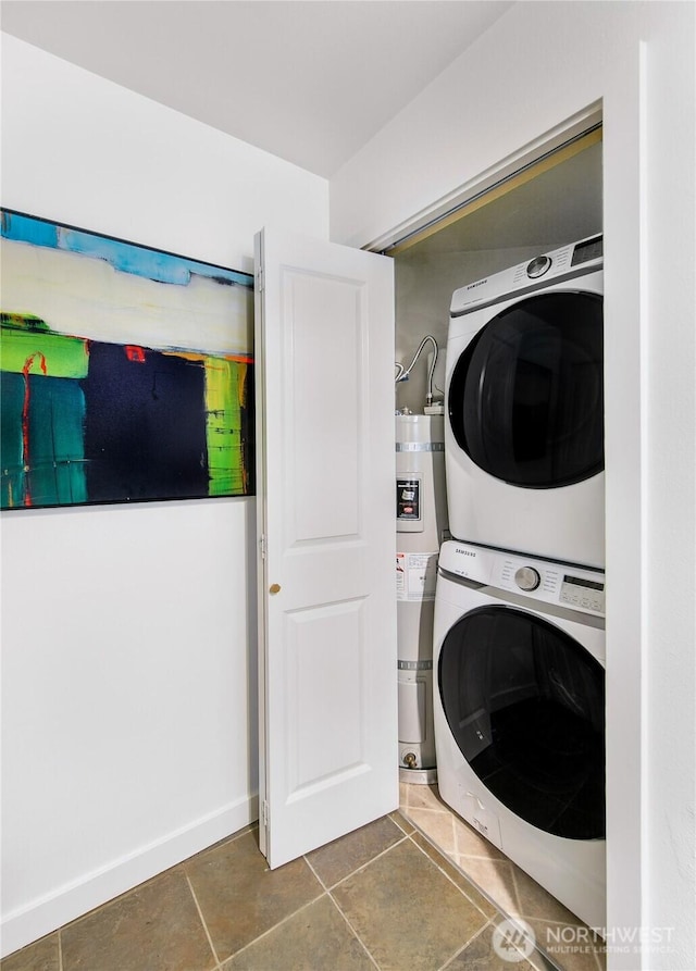 laundry area with baseboards, stacked washing maching and dryer, water heater, tile patterned floors, and laundry area