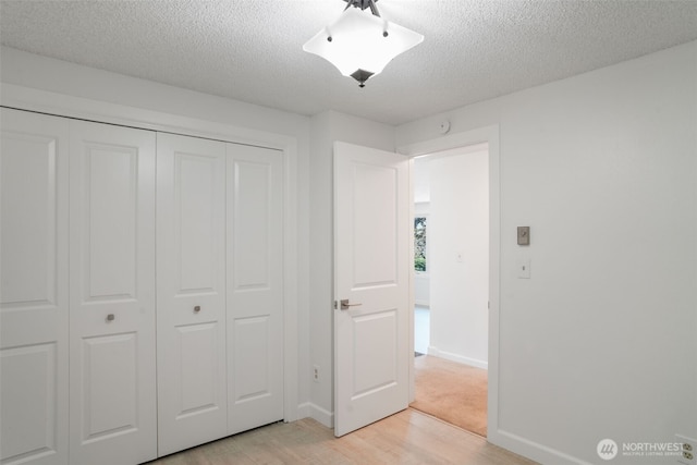 8305 NW Fruit Valley Rd, Vancouver, WA 98665 - unfurnished bedroom featuring a textured ceiling, light wood-type flooring, baseboards, and a closet