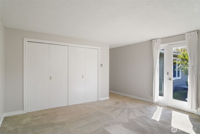 8305 NW Fruit Valley Rd, Vancouver, WA 98665 - unfurnished bedroom with a textured ceiling, a closet, access to outside, and carpet floors