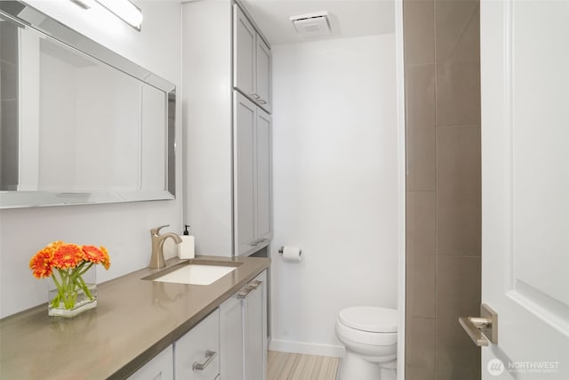 8305 NW Fruit Valley Rd, Vancouver, WA 98665 - bathroom featuring visible vents, toilet, vanity, and baseboards
