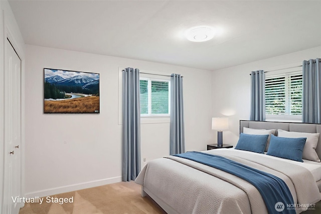 8305 NW Fruit Valley Rd, Vancouver, WA 98665 - bedroom featuring multiple windows, a closet, baseboards, and light carpet