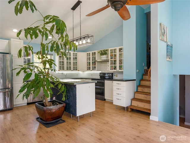 486 Wren Rd, Lopez Island, WA 98261 - kitchen featuring white cabinets, electric range, light wood-style flooring, and freestanding refrigerator