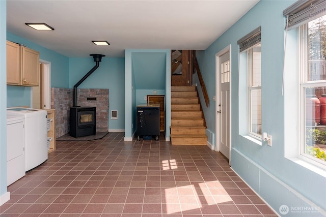 486 Wren Rd, Lopez Island, WA 98261 - unfurnished living room with stairway, separate washer and dryer, a wood stove, and baseboards