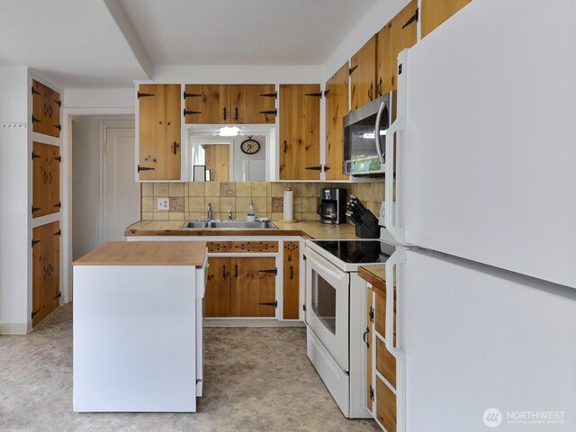 kitchen with tasteful backsplash, open shelves, brown cabinets, a sink, and white appliances