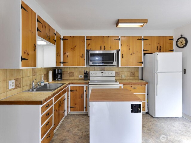 kitchen with a sink, decorative backsplash, tile countertops, and white appliances