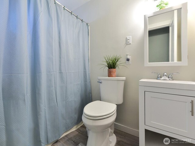 full bath featuring vanity, baseboards, toilet, and wood finished floors