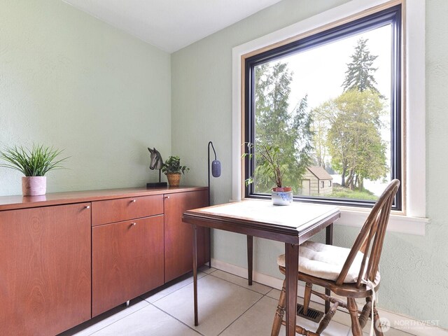 dining room featuring baseboards and light tile patterned floors