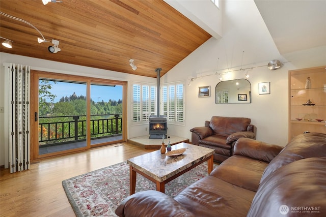 living area with wood ceiling, a wood stove, high vaulted ceiling, and wood finished floors