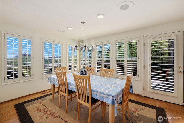 dining space with recessed lighting, baseboards, a chandelier, and wood finished floors