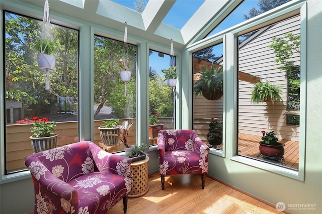 sunroom featuring plenty of natural light, lofted ceiling with skylight, and wood finished floors