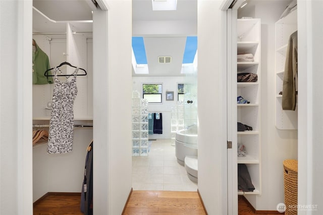 spacious closet featuring a skylight, visible vents, and tile patterned flooring