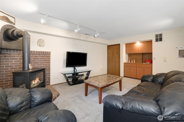 living area featuring visible vents, rail lighting, and light carpet