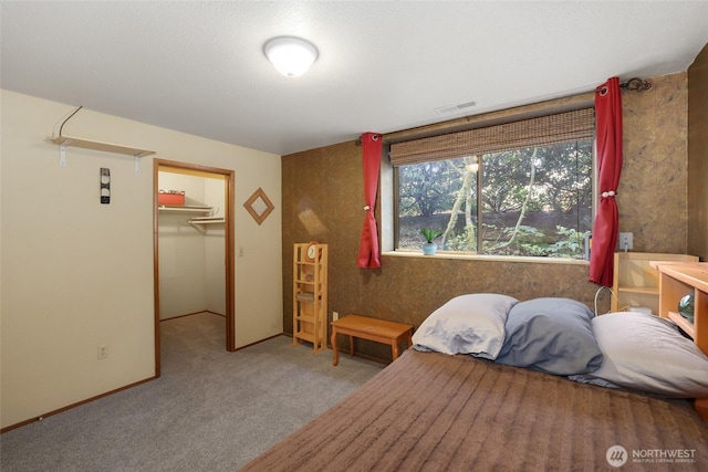 bedroom with visible vents, carpet, a walk in closet, and a closet