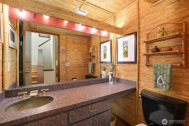 bathroom with wooden walls, wooden ceiling, and vanity