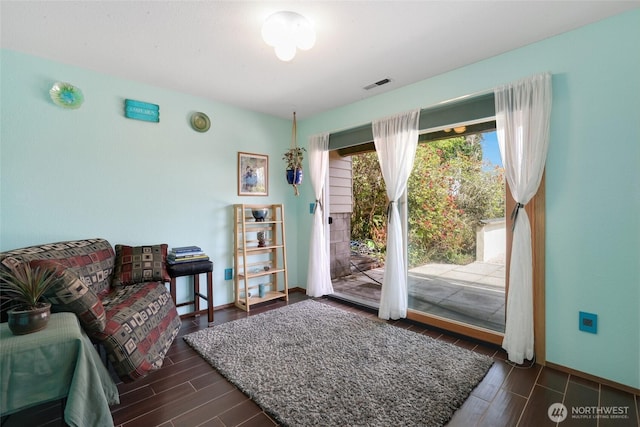 doorway to outside with wood finish floors, visible vents, and baseboards