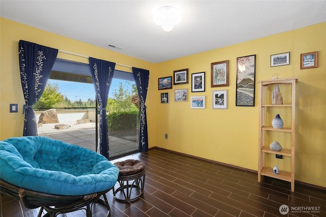 sitting room featuring visible vents, baseboards, and dark wood-type flooring