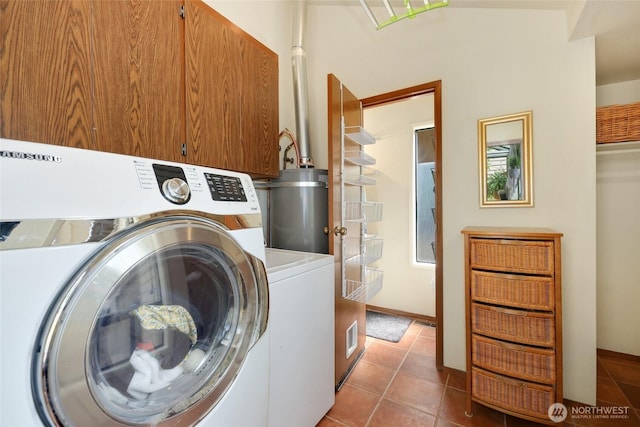 washroom featuring washer / clothes dryer, tile patterned flooring, water heater, and cabinet space