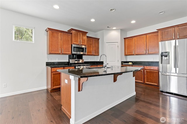 4000 Cameron Dr NE, Lacey, WA 98516 - kitchen featuring appliances with stainless steel finishes, a breakfast bar, brown cabinetry, dark wood-style floors, and recessed lighting