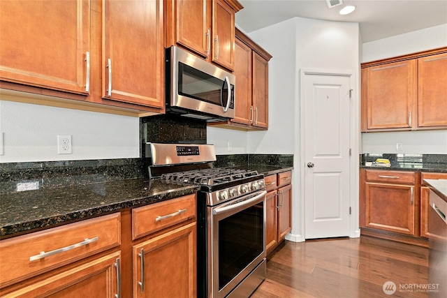 4000 Cameron Dr NE, Lacey, WA 98516 - kitchen with appliances with stainless steel finishes, wood finished floors, dark stone counters, and brown cabinetry