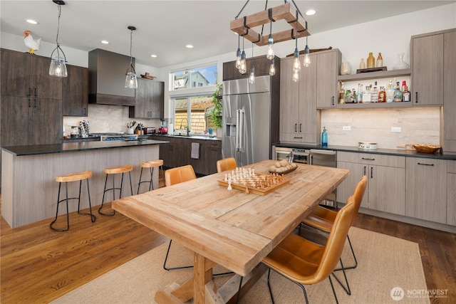 dining room featuring dark wood-style flooring, recessed lighting, and a bar