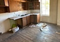 kitchen with wood finished floors, light countertops, brown cabinetry, and a sink