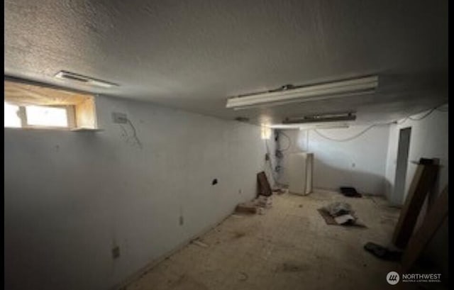 below grade area with visible vents and a textured ceiling