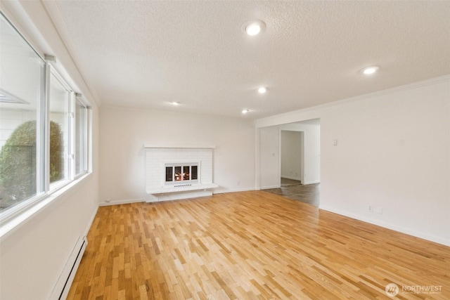 unfurnished living room featuring crown molding, a textured ceiling, light wood-style flooring, and a baseboard radiator