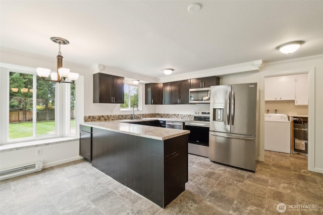 kitchen featuring dark brown cabinetry, appliances with stainless steel finishes, a notable chandelier, a peninsula, and washer / dryer
