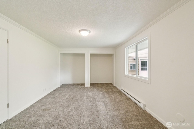 unfurnished bedroom with carpet floors, a textured ceiling, multiple closets, a baseboard radiator, and ornamental molding