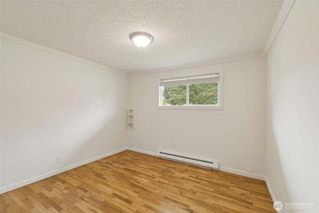 empty room featuring ornamental molding, light wood-style floors, baseboards, a textured ceiling, and a baseboard radiator