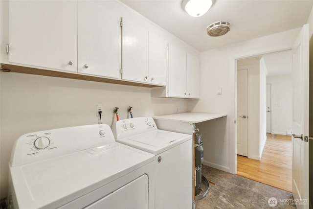 laundry area with baseboards, cabinet space, and washer and dryer