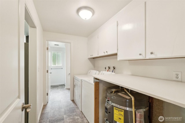 clothes washing area with separate washer and dryer, cabinet space, and baseboards