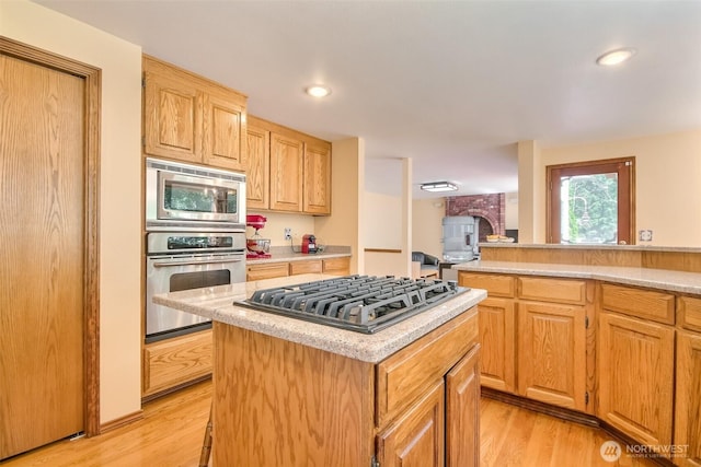209 SW 331st Pl, Federal Way, WA 98023 - kitchen with appliances with stainless steel finishes, light countertops, a kitchen island, light wood-type flooring, and recessed lighting
