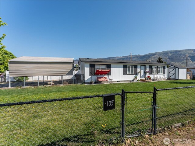 105 3rd St SW, Rock Island, WA 98850 - view of front of home featuring a fenced backyard, a gate, a mountain view, and a shed