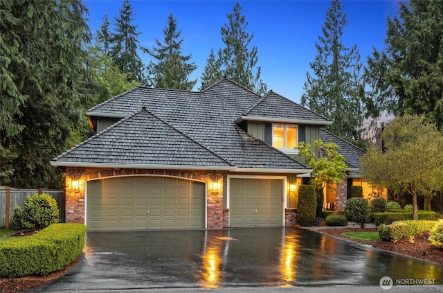 traditional home featuring an attached garage, board and batten siding, fence, and driveway