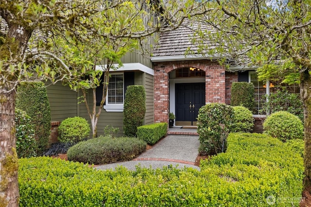 view of exterior entry featuring brick siding