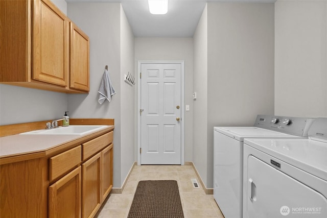 laundry room featuring washer and dryer, baseboards, a sink, and cabinet space