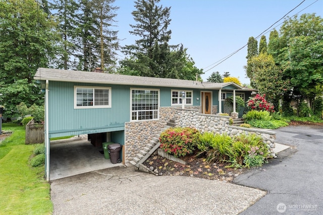 1302 Spruce St, Longview, WA 98632 - view of front facade with a carport, asphalt driveway, stone siding, and a chimney