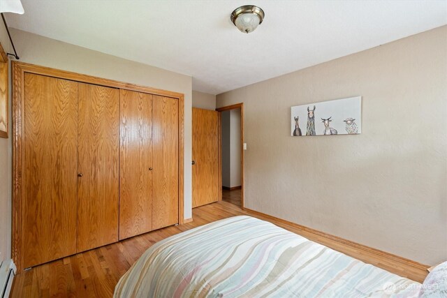 1302 Spruce St, Longview, WA 98632 - bedroom with a baseboard heating unit, wood finished floors, a closet, and baseboards