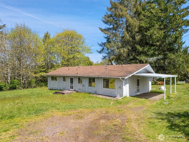 back of property with a lawn, driveway, and board and batten siding