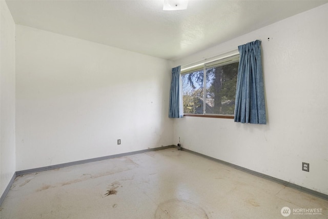 unfurnished room featuring baseboards
