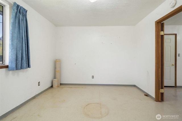 unfurnished room featuring baseboards