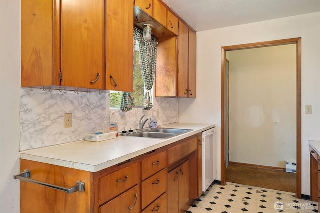 kitchen with a sink, white dishwasher, tasteful backsplash, and light countertops