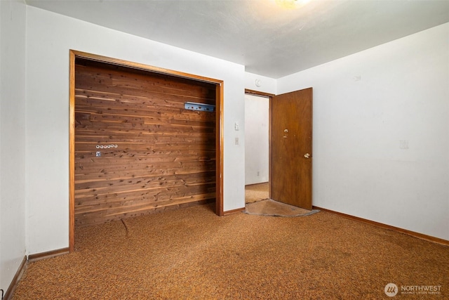 unfurnished bedroom featuring baseboards, a closet, and carpet flooring