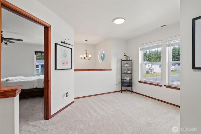 empty room with a wealth of natural light, visible vents, carpet flooring, and baseboards