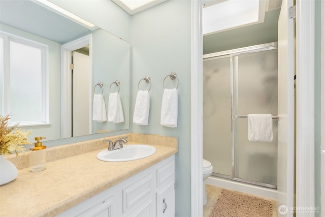 bathroom with vanity, visible vents, toilet, and a shower stall