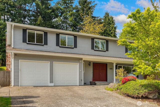 traditional-style home with a garage and aphalt driveway