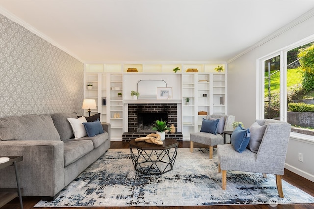 living room with crown molding, wood finished floors, baseboards, an accent wall, and wallpapered walls