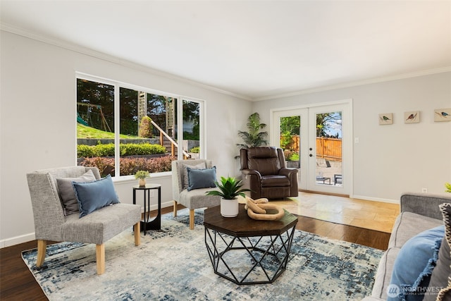 living area with french doors, baseboards, ornamental molding, and wood finished floors